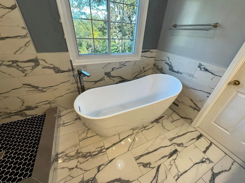 Newly remodeled residential bathroom with new tub and flooring