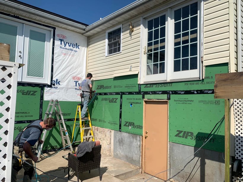 Yellowish vinyl siding being installed on home